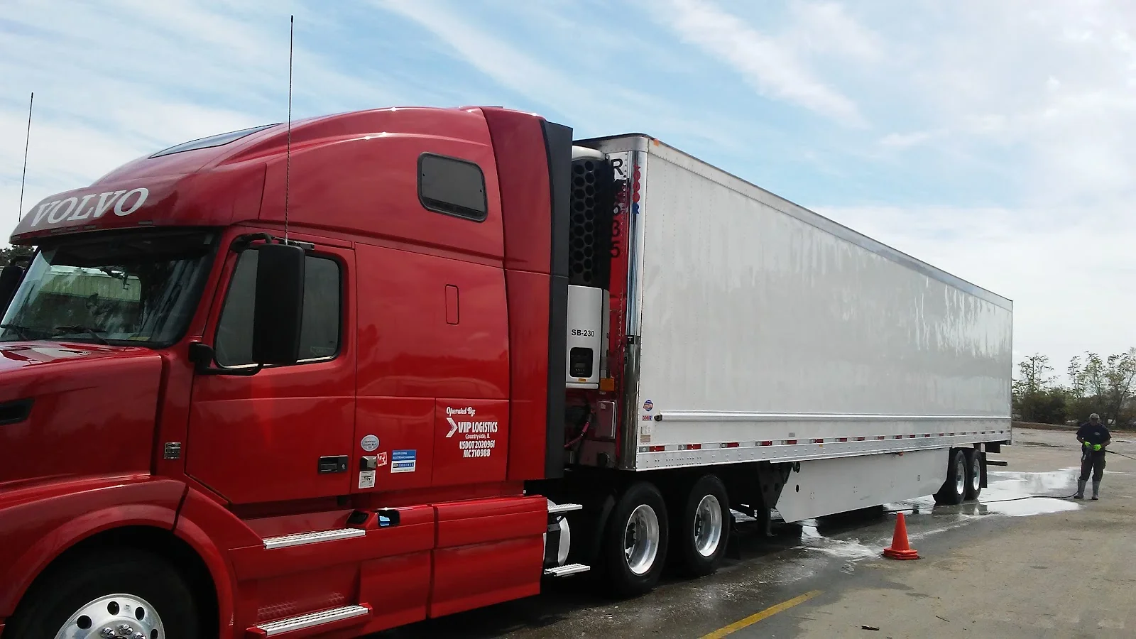 Red Volvo tractor and trailer getting washed at Gulf Coast Fuel and Wash-Out
